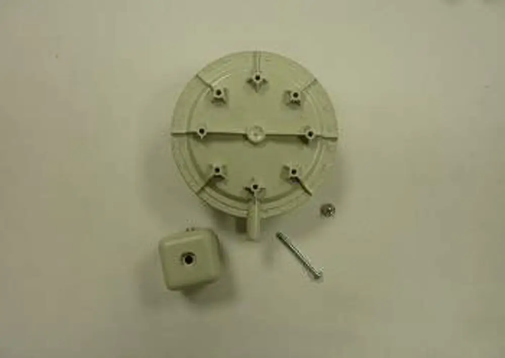 Gasdruckwächter-Set mit runder Halterung und einem kleinen quadratischen Element in heller Farbe. Zubehörteile wie Schrauben sind ebenfalls abgebildet. Remeha ist die Herstellermarke.